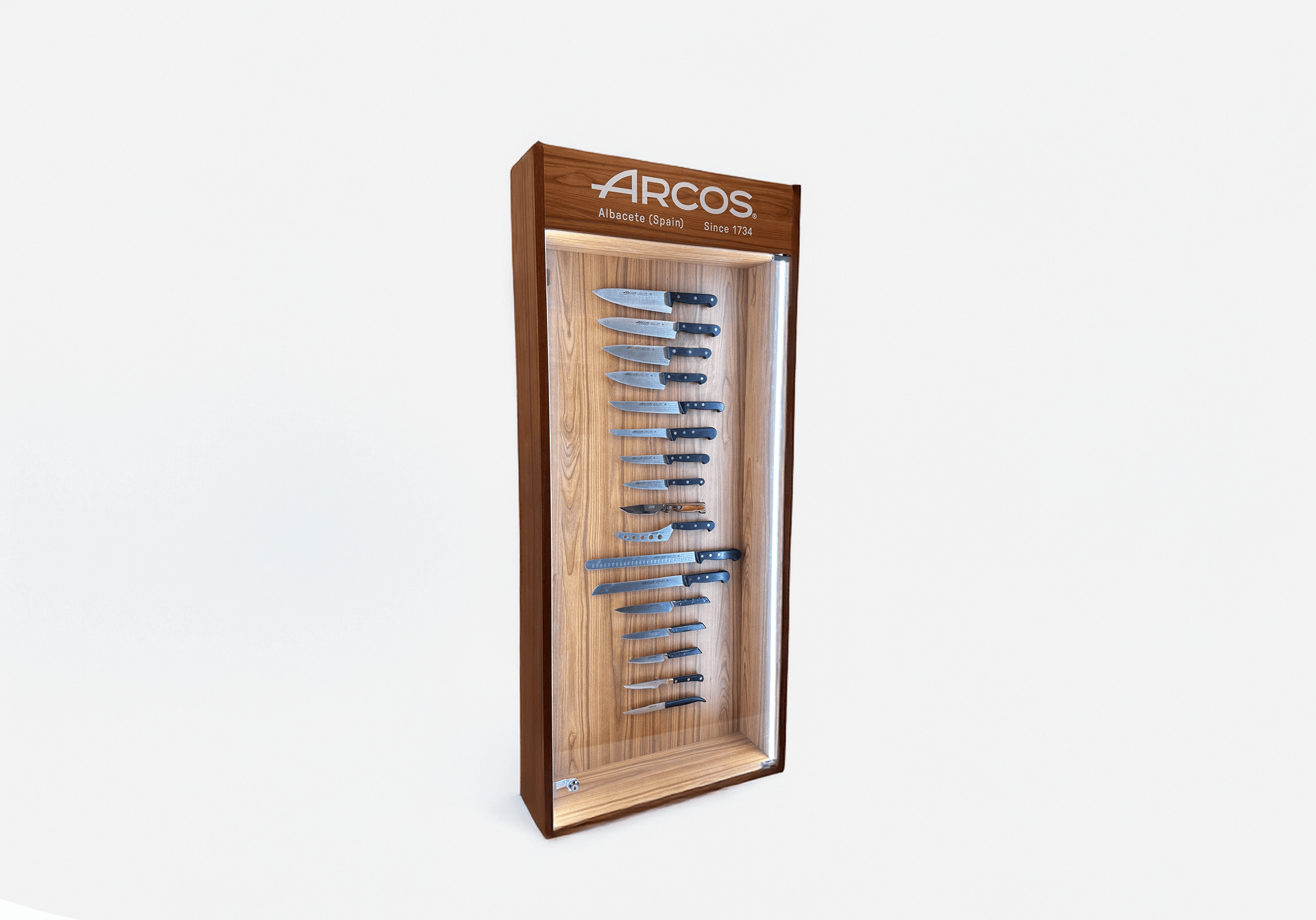 Wooden display cabinet with Arcos kitchen knives organized in vertical holders.
