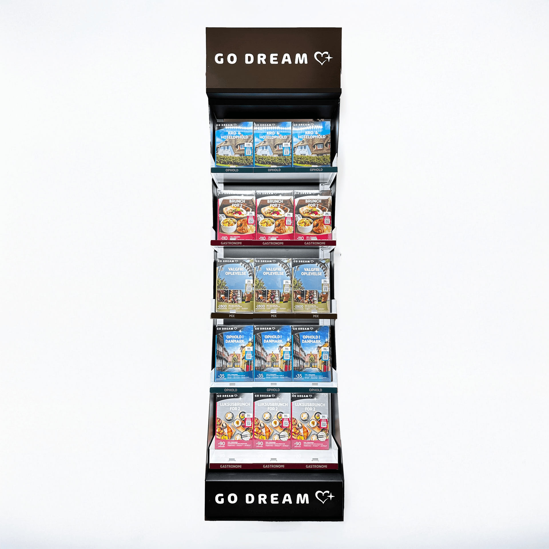 Expositor iluminado de suelo con varias bandejas inclinadas que sostienen cajas de experiencias. En la parte superior e inferior lleva el logotipo “GO DREAM”, y está diseñado para mostrar productos organizados por temáticas.
