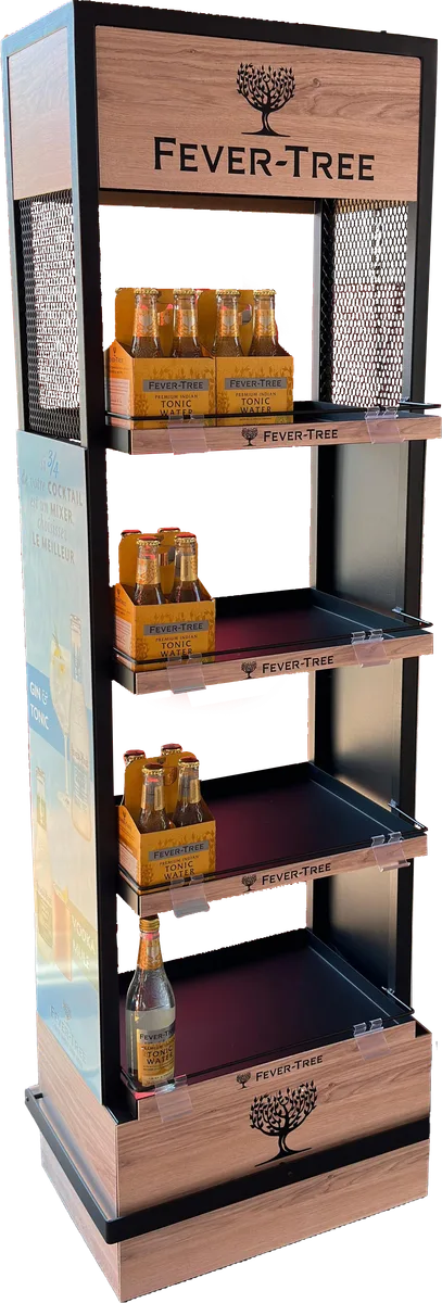 Expositor de suelo de Fever-Tree con estructura de acero negro, laterales de malla perforada en la parte alta, cabecera, frentes de balda y zócalo en acabado roble y cuatro bandejas con packs de tónica
